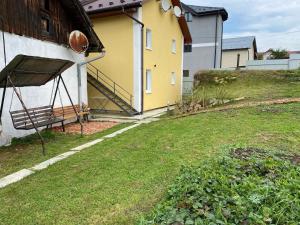 une cour avec une maison et un champ herbeux dans l'établissement Villa Vella, à Skhidnitsa