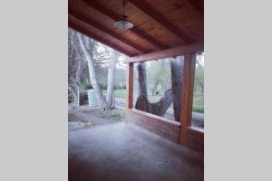 una pantalla en el porche de una casa con árboles en La Casita de Drofa Gabets en Trelew