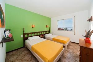2 camas en una habitación con paredes verdes en Apartamentos Casa Blanca, en Miami Platja
