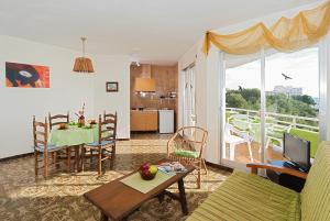 - un salon avec une table et une salle à manger dans l'établissement Apartamentos Casa Blanca, à Miami Platja