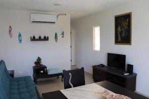 a living room with a blue couch and a television at Departamento Marina Diamante XA 6 personas in Acapulco