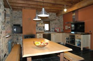 a kitchen with a bowl of fruit on a wooden table at CASA en Cofiñal in Cofiñal