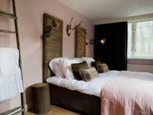 1 dormitorio con 1 cama con sábanas y almohadas blancas en Hotel & Restaurant Meneer Van Eijck, en Oisterwijk
