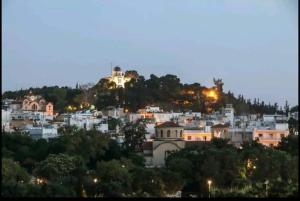 Blick auf die Stadt in der Nacht in der Unterkunft ENILION ATHENS , CITY CENTER WITH VIEW TO ACROPOLIS in Athen