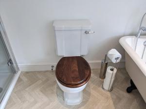 ein Badezimmer mit einem WC, einem Holzsitz und einem Waschbecken in der Unterkunft Luxury townhouse in town centre, views, river walk, Free Parking in Shrewsbury + 32 Fotos