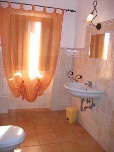 a bathroom with a sink and a toilet and a window at Agriturismo La Villa in Bolano