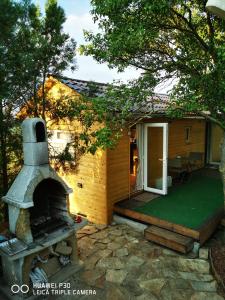 une petite maison avec un poêle à bois dans la cour dans l'établissement Csillaghegyi Oázis, à Siófok