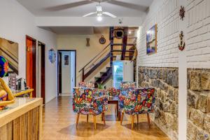 a dining room with two chairs and a staircase at Pousada Galeão Itacaré in Itacaré