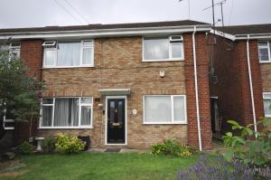 a red brick house with a black door at Modern 2 Bed Apartment in Luton