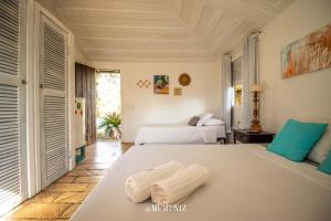 a bedroom with two beds in a room at Morada do Sol Guest House in Búzios +93 photos