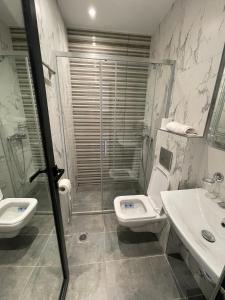 een badkamer met een douche, een toilet en een wastafel bij Meudsa Grand Agia Triada in Agia Triada