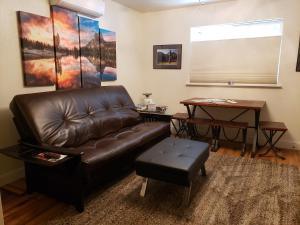 a living room with a leather couch and a table at Yosemite Foothill Retreat in Coarsegold