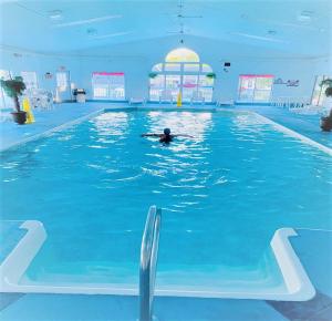 una persona nadando en una gran piscina en Exit 5 Resort & Condominium en Saco