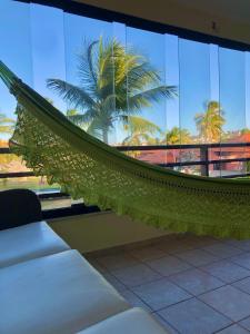 a hammock in a building with a palm tree at Aquaville Condomínio in Aquiraz