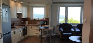 a kitchen with white cabinets and a table and chairs at 17 WIDOK in Polańczyk