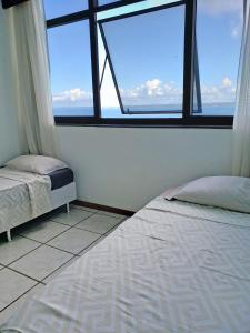 two beds in a room with two windows at Sol Vitória Marina - Mahi Mahi - Corredor da Vitória in Salvador