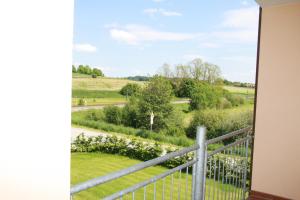 einen Balkon mit Blick auf ein Feld in der Unterkunft Aparthotel Altomünster - Garni in Altomünster