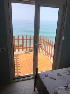 a bedroom door with a view of the ocean at Villa John in Borsh