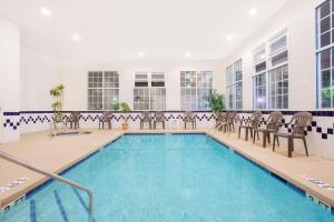 默特尔比奇SureStay Hotel by Best Western North Myrtle Beach的一个带椅子的室内游泳池和游泳池