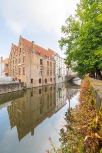 un canal dans une ville avec des bâtiments et un pont dans l'établissement Hotel Ter Brughe by CW Hotel Collection, à Bruges