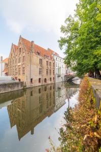 a river with houses and trees in front of it at Hotel Ter Brughe in Bruges