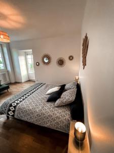 1 dormitorio con cama y espejo en la pared en LA BUTTE - Maison de vacances Avranches avec vue sur le Mont Saint Michel, en Le Val-Saint-Père