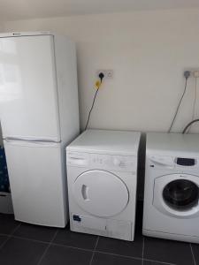 eine Waschküche mit einem Kühlschrank und einer Waschmaschine in der Unterkunft Snowdonia View on Isle of Anglesey in Menai Bridge