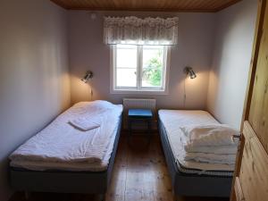 two beds in a small room with a window at Wannborga Vingård in Köpingsvik