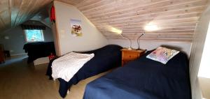 Postel nebo postele na pokoji v ubytování Lidsbergs torp i Ölme från år 1910 Ett eget mysigt torp med kakelugn, lågt i tak, sovrum med dubbelsäng och 2 enkelsängar på loft med snedtak bäddsoffa i v-rum trädgård med gasgrill