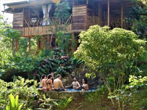 莫科阿Huaca Huaca Hostel的一群身穿泳衣的人坐在瀑布里