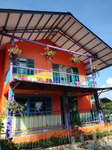 ein orangefarbenes Gebäude mit Balkonen und Blumen darauf in der Unterkunft Finca San Miguel Filandia in Filandia