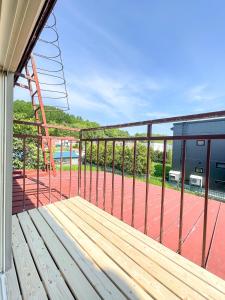 un banco de madera en un balcón con pista de tenis en 旭川美瑛 Sakura 西神楽, en Asahikawa
