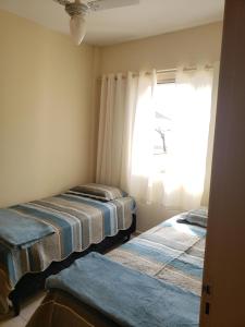 três camas num quarto com uma janela em Apto central com estacionamento - Faculdade Odonto em Araraquara