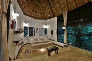 莫雷洛斯港Jolie Jungle Eco Hotel的一间带床和大窗户的卧室