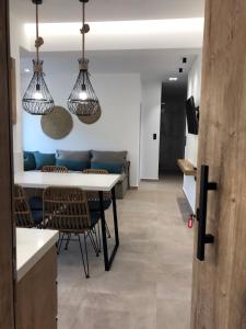 cocina y sala de estar con mesa y sillas en blue sea suites, en Tsoutsouros