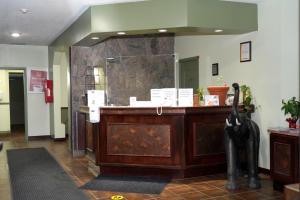 een lobby met een receptie en een grote spiegel bij Econolodge Huntsville in Huntsville