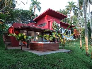 una casa roja en una colina con palmeras en Tierra Negra Suite en Pereira