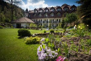 un gran edificio con un jardín delante de él en Hotel Las Piechowice en Szklarska Poręba