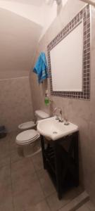 W łazience znajduje się umywalka, toaleta i lustro. w obiekcie Lo del Chango w mieście Purmamarca