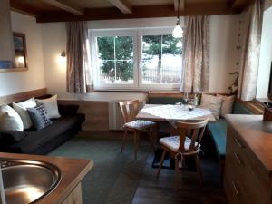 uma cozinha e sala de estar com uma mesa e um sofá em Petter 1 em Tobadill