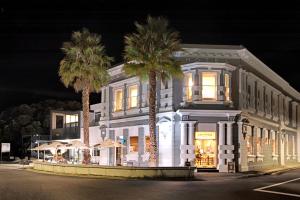 卡塔尼的住宿－The Com Plex Motel，一座白色的建筑,前面有棕榈树