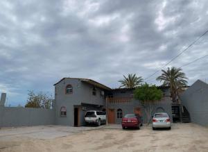 a house with two cars parked in front of it at Orange condo in San Felipe