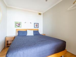 1 dormitorio con 1 cama azul en una habitación en Blue Vista,9,13 Victoria Parade - Studio with stunning water views and air conditioning, en Nelson Bay