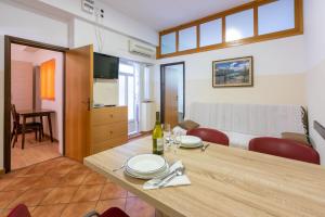une salle à manger avec une table et un salon dans l'établissement Apartment Luksi, à Selce