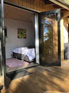 a room with a bed and a sliding glass door at Golden Bay Glamping in Takaka