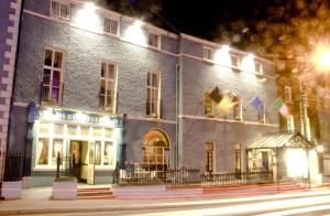 a lit up building on a city street at night at Club House Hotel Kilkenny in Kilkenny
