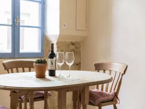 una mesa con una botella de vino y dos copas de vino en Apartment near the river in Bize Minervois, en Bize-Minervois