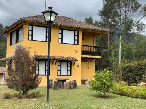 ein gelbes Haus mit Straßenlicht davor in der Unterkunft CASA CAMPESTRE VILLA SANTANA in Villa de Leyva