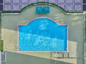 an overhead view of a swimming pool with two blue chairs at Hotel Canton in Guangzhou