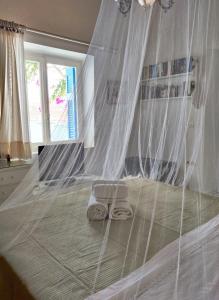 a bedroom with a bed with a mosquito net at Family house by the seaside of Karavostasis in Karavostasi